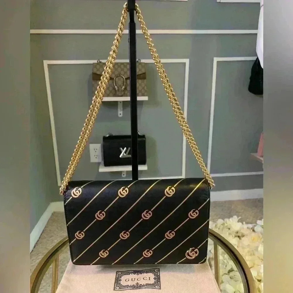 Gucci mini leather chain bag with double G stripe in black and gold.